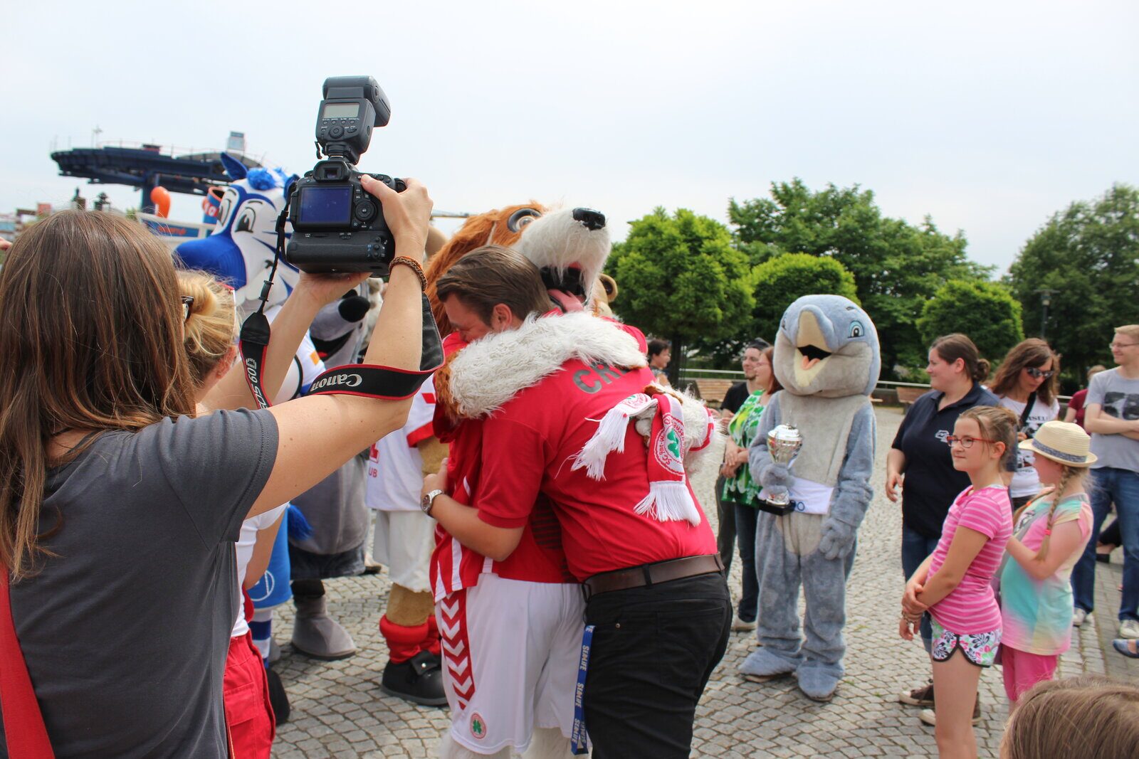 Fabian Richter umarmt ein Park-Maskottchen bei einem Dreh